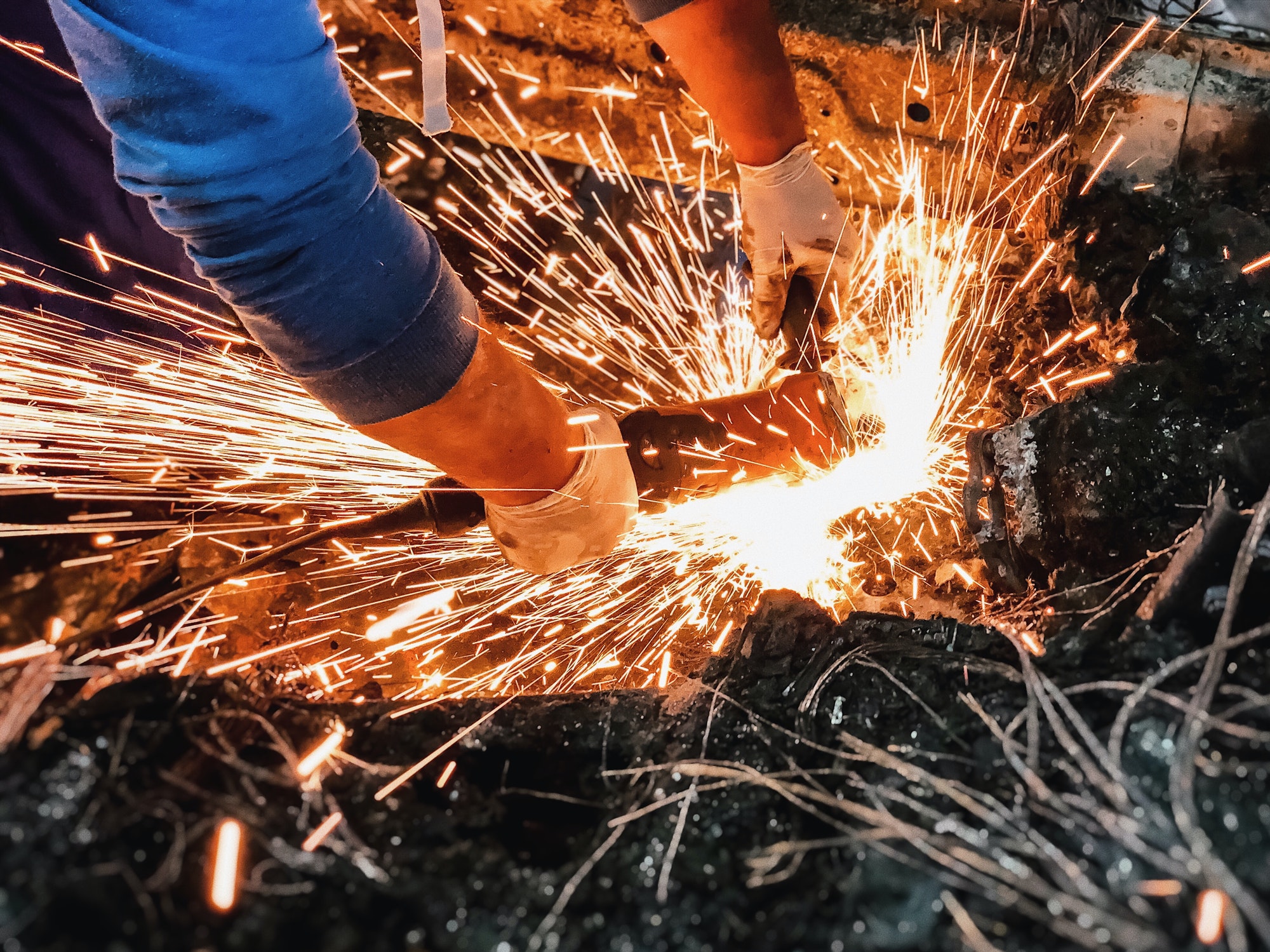 A worker cutting thru metal scraps